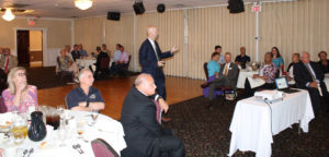 Dr. Wagner is shown gesturing as he speaks to the luncheon crowd at the Cottage Green. (Photo by Don Brennan)